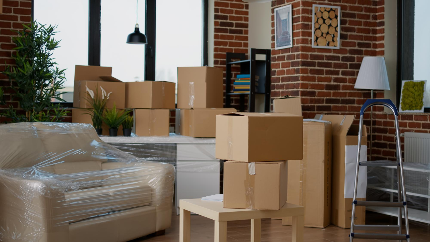 Un déménagement est en cours avec des cartons et meubles entreposés dans une pièce
